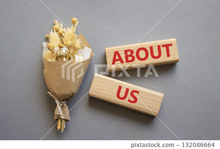About us symbol. Concept word About us on wooden blocks. Beautiful grey background with bouquet of flowers. Business and About us concept. Copy space About us symbol. Concept word About us on wooden blocks. Beautiful grey background with bouquet of flowers. Business and About us concept. Copy space 132086664
