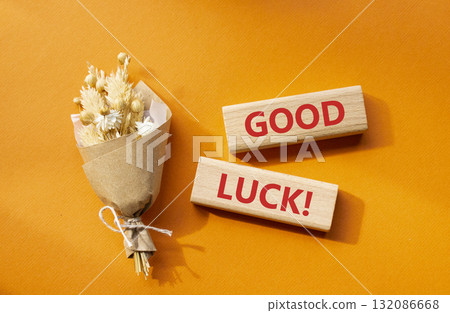 Good luck symbol. Wooden blocks with words Good luck. Beautiful orange background with bouquet of flowers. Business and Good luck concept. Copy space. 132086668