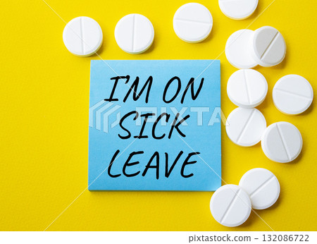 Sick leave symbol. Concept word I am on sick leave on blue note. Beautiful yellow background with pills. Medicine and I am on sick leave concept. Copy space Sick leave symbol. Concept word I am on sick leave on blue note. Beautiful yellow background with pills. Medicine and I am on sick leave concept. Copy space 132086722