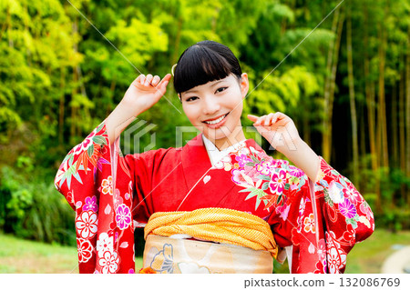 A Japanese woman wearing a furisode kimono standing in a bamboo forest A Japanese woman wearing a furisode kimono standing in a bamboo forest 132086769