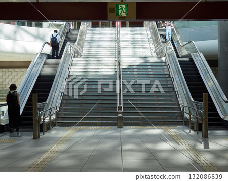 Commuters riding the escalators in the Motenashi Dome underground plaza at Kanazawa Station on a summer morning 132086839