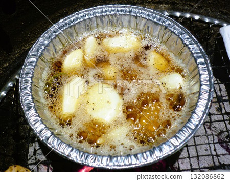 Garlic being grilled on a charcoal grill 132086862