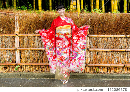 A Japanese woman wearing a furisode kimono standing in a bamboo forest A Japanese woman wearing a furisode kimono standing in a bamboo forest 132086878