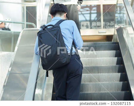 夏日早晨，一名男職員在城市商業中心的自動扶梯上下班 132087115