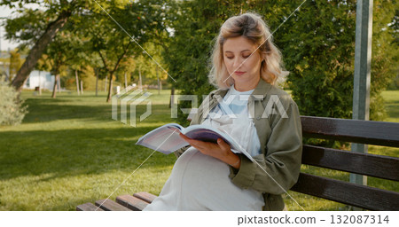 Woman reading books about pregnancy. 132087314