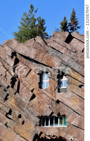 House on the Rock structure featuring windows embedded within a rocky facade. Antwerp, Belgium 132087647