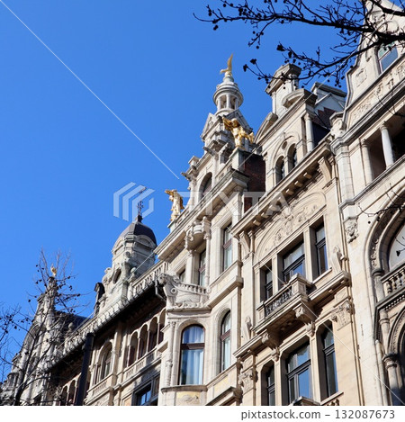 Ornate facade of historic building in Antwerp, Belgium, featuring sculptures and architectural details under blue sky 132087673