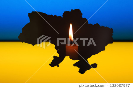 Ukraine blackout due to the war. A flickering candle is the sole source of light, placed near a map of Ukraine or a national flag. attacks on electric energy infrastructure by Russia Ukraine blackout due to the war. A flickering candle is the sole source of light, placed near a map of Ukraine or a national flag. attacks on electric energy infrastructure by Russia 132087977