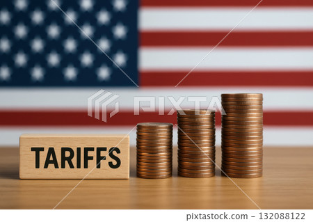 Serious view on tariffs and trade, this financial policy with an import tax impacts USA economy, shown by stacked coins before blurred American flag concept 132088122