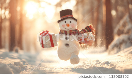 A charming, cheerful snowman character wearing a top hat and plaid scarf, leaping in the snow while holding two christmas gifts. The scene is set in a winter forest with soft, warm sunlight 132088502