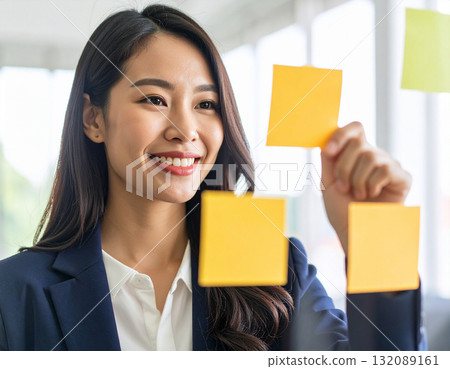 A young woman putting a sticky note A young woman putting a sticky note 132089161