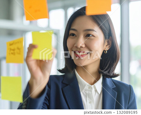 A young woman putting a sticky note 132089195