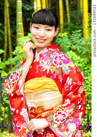 A Japanese woman wearing a furisode kimono standing in a bamboo forest A Japanese woman wearing a furisode kimono standing in a bamboo forest 132089583