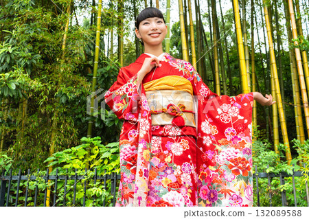 A Japanese woman wearing a furisode kimono standing in a bamboo forest 132089588