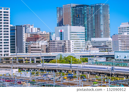 A rare sight of two Shinkansen trains lined up in the Tokyo cityscape of Japan. In the background are tower apartment buildings in Shibaura. A rare sight of two Shinkansen trains lined up in the Tokyo cityscape of Japan. In the background are tower apartment buildings in Shibaura. 132090912