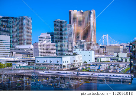 日本東京城市景觀中罕見的兩列新幹線列車並排而行的景象。背景是芝浦的高層公寓大樓,包括芝浦島岬塔。 日本東京城市景觀中罕見的兩列新幹線列車並排而行的景象。背景是芝浦的高層公寓大樓,包括芝浦島岬塔。 132091018