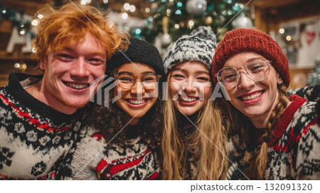 Joyful portrait of four happy, smiling young adults in patterned Christmas sweaters and knit hats, celebrating the holiday season indoors. Blurred Christmas tree in the background Joyful portrait of four happy, smiling young adults in patterned Christmas sweaters and knit hats, celebrating the holiday season indoors. Blurred Christmas tree in the background 132091320