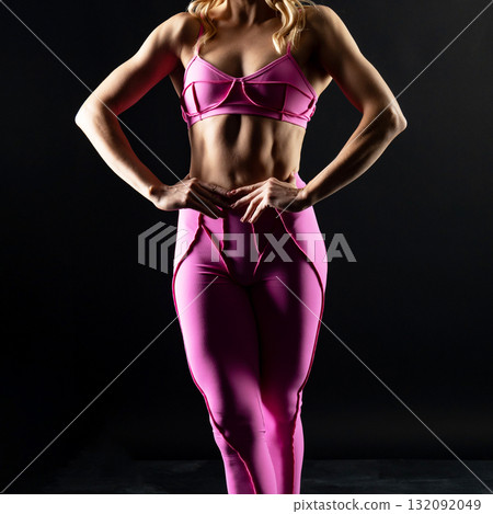 athletic female body in pink sportswear on dark background, fitness woman, athletic girl torso athletic female body in pink sportswear on dark background, fitness woman, athletic girl torso 132092049