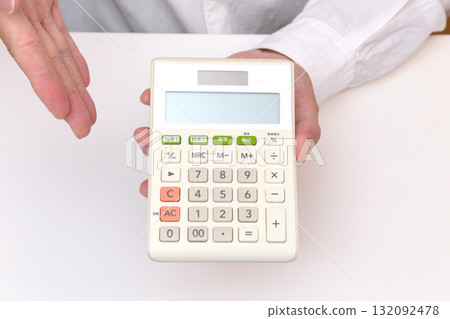 The hand of a person holding a calculator 132092478