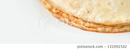 Close-up of a freshly baked golden brown flatbread on white background Close-up of a freshly baked golden brown flatbread on white background 132092582