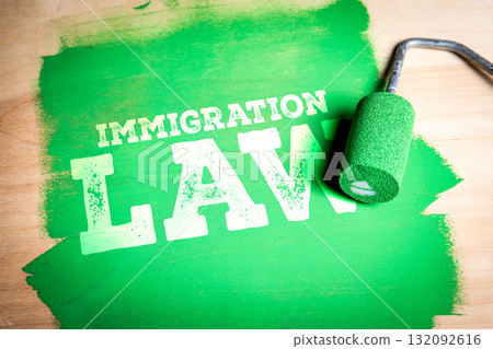 Immigration Law. Paint roller covering wooden surface in green and text immigration law appearing 132092616