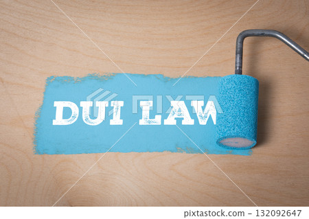 Concept of DUI law with paint roller applying blue paint on wooden surface 132092647