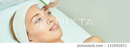 Caucasian young female undergoing facial treatment in spa with ultrasonic skin Caucasian young female undergoing facial treatment in spa with ultrasonic skin 132092651