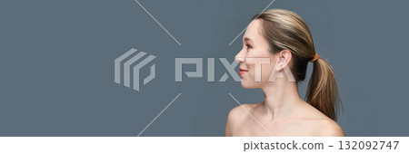 Profile of young caucasian female with ponytail against gray background 132092747
