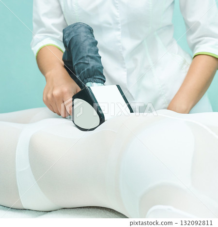 Female adult receiving anti-cellulite treatment with professional equipment 132092811