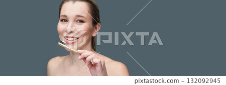 Caucasian adult female smiling while brushing teeth with eco-friendly bamboo Caucasian adult female smiling while brushing teeth with eco-friendly bamboo 132092945
