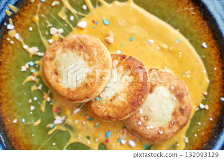 Delicious golden pancakes with cream and colorful sprinkles on green and yellow Delicious golden pancakes with cream and colorful sprinkles on green and yellow 132093129
