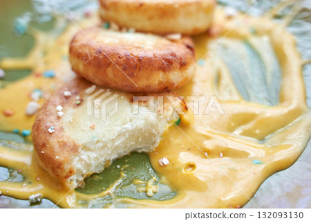 Close-up of freshly prepared syrniki pancakes with sweet condensed milk Close-up of freshly prepared syrniki pancakes with sweet condensed milk 132093130