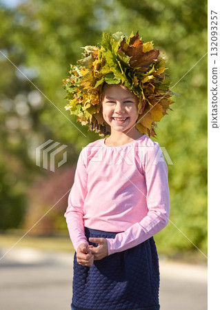 Smiling caucasian young girl with leaf crown outdoors in autumn Smiling caucasian young girl with leaf crown outdoors in autumn 132093257