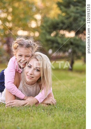 Young caucasian mother and child playing on grass in park with happy smiles Young caucasian mother and child playing on grass in park with happy smiles 132093258