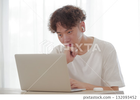 在客廳裡的計算機上工作的年輕人 132093452