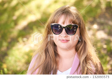 Young caucasian woman with long hair wearing sunglasses and pink blazer Young caucasian woman with long hair wearing sunglasses and pink blazer 132093573