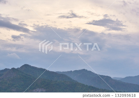 Serene cloudy sky over peaceful mountain range at dusk captured in tranquil Serene cloudy sky over peaceful mountain range at dusk captured in tranquil 132093618