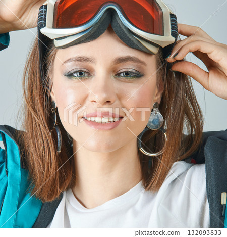 Young caucasian female snowboarder preparing for winter adventure with ski Young caucasian female snowboarder preparing for winter adventure with ski 132093833
