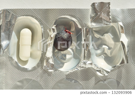 Contrasting elements of medicine and nature: capsule next to grape in metallic 132093906