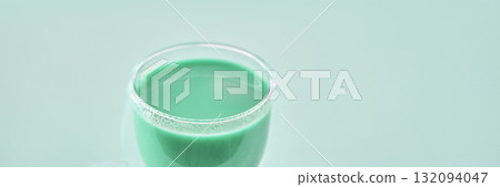 Close-up of a glass of fresh green smoothie with a minimalist background Close-up of a glass of fresh green smoothie with a minimalist background 132094047