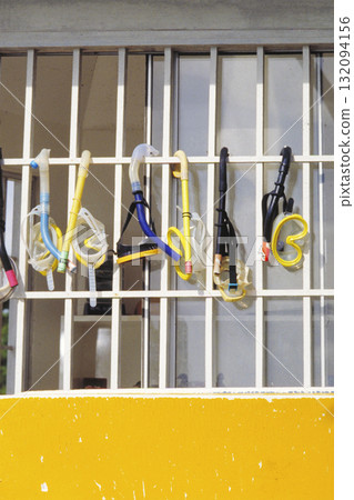 A snorkel and mask hanging on a window grille A snorkel and mask hanging on a window grille 132094156