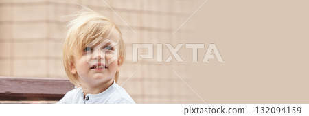 Caucasian young blonde male child with long hair wearing white shirt outdoors Caucasian young blonde male child with long hair wearing white shirt outdoors 132094159