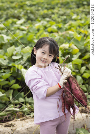 Cute girl harvesting sweet potatoes Cute girl harvesting sweet potatoes 132094218