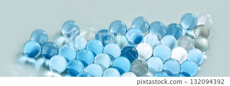 Collection of transparent blue and clear marbles on light background in various 132094392