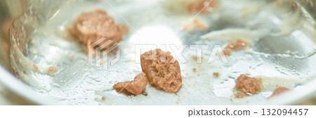 Close-up of cooked meat leftovers in stainless steel pan after frying Close-up of cooked meat leftovers in stainless steel pan after frying 132094457