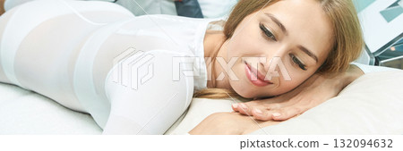 Young caucasian female relaxing during spa treatment in white outfit smiling Young caucasian female relaxing during spa treatment in white outfit smiling 132094632