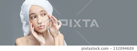 Young caucasian female applies gold eye patch for skincare routine on gray Young caucasian female applies gold eye patch for skincare routine on gray 132094689