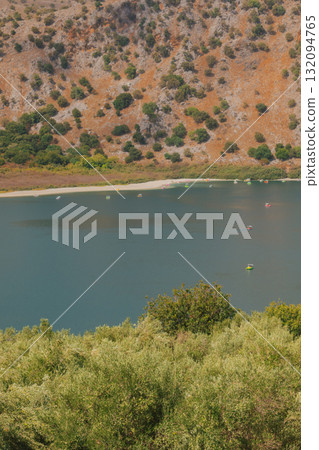 Hidden mountain lake with calm turquoise water red rocks and green trees. Hidden mountain lake with calm turquoise water red rocks and green trees. 132094765