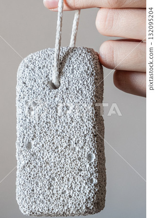 A close-up of a pumice stone for the foot. The background is neutral and simple. A close-up of a pumice stone for the foot. The background is neutral and simple. 132095204