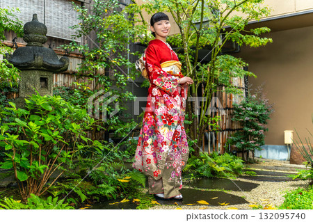Japanese woman wearing a furisode kimono standing in the garden 132095740
